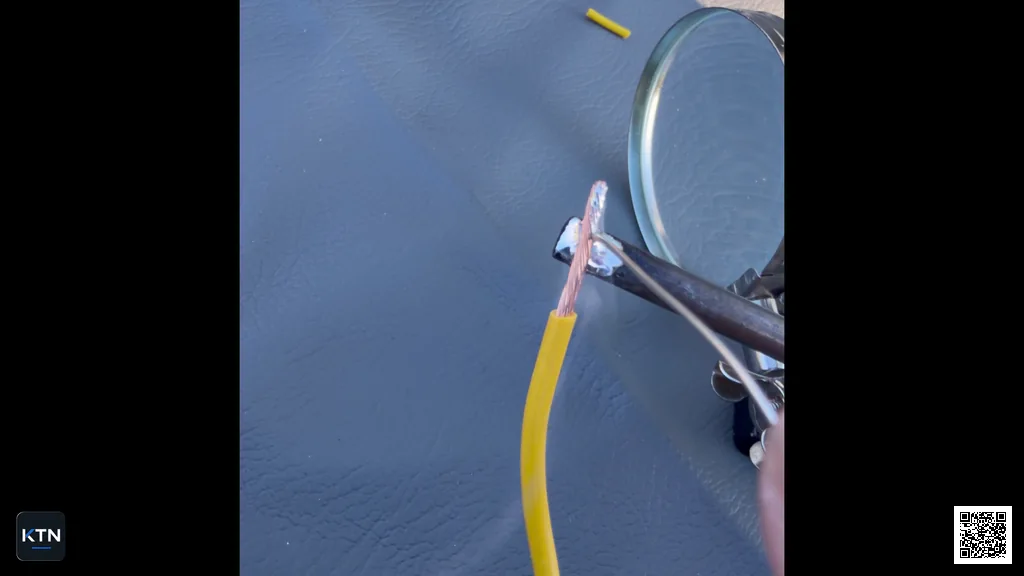 Soldering iron heating the copper strands in a yellow wire end