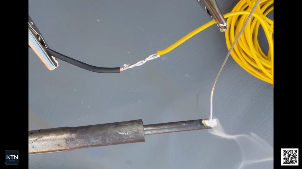 Soldering iron heating the mechanically locked wire splice from below