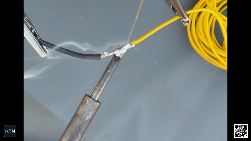 Wire splice being kept hot while the solder spreads between the conductors