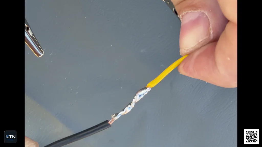 Finished soldered splice between a black and a yellow wire