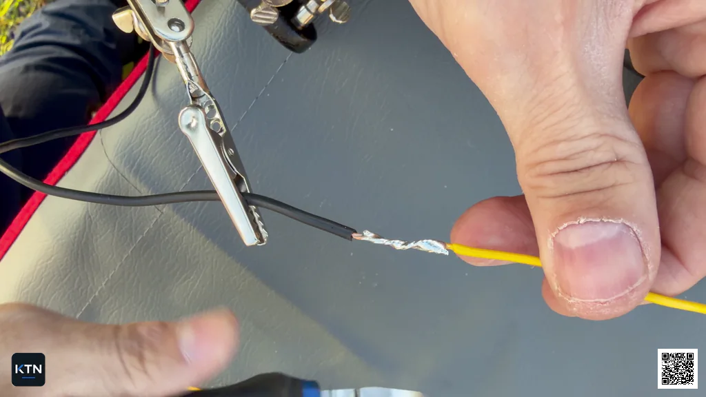 Fingers checking the soldered wire splice for sharp strand ends