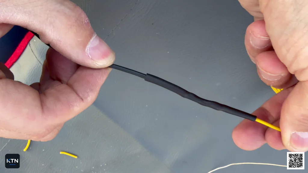 Finished wire splice protected by evenly shrunk black heat-shrink tubing